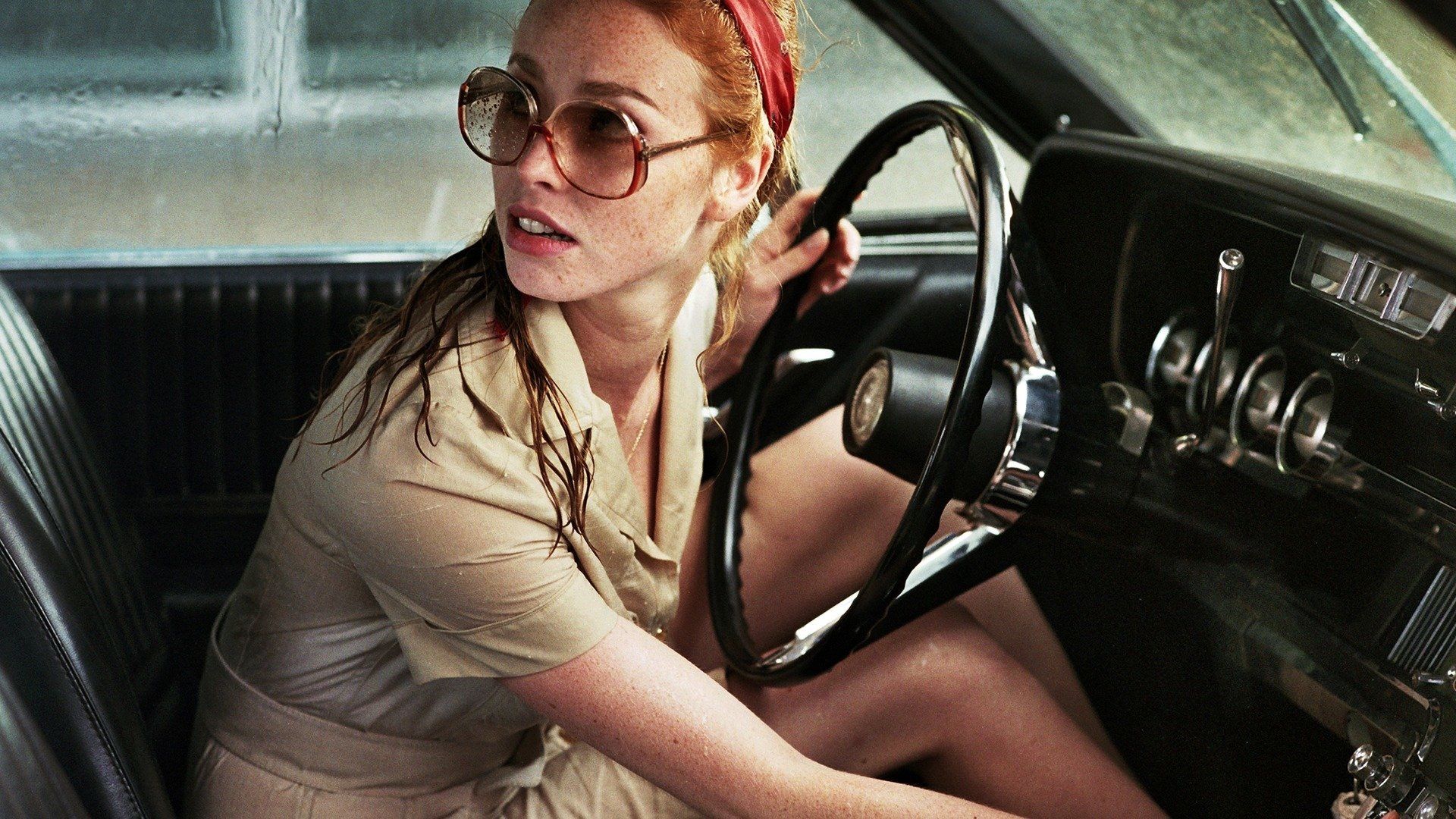 The Lady in the Car with Glasses and a Gun Backdrop